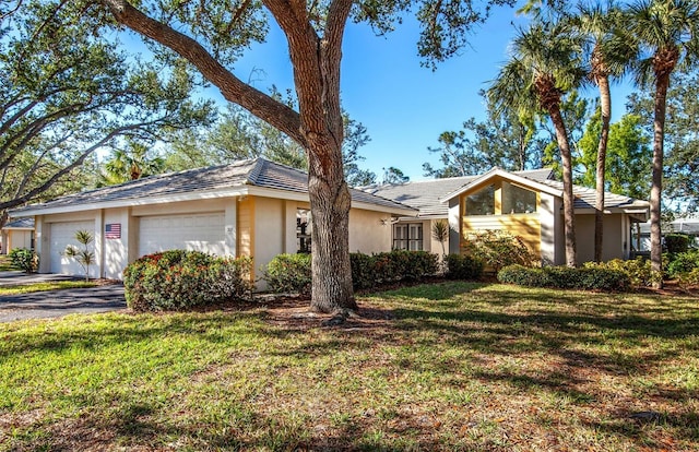 ranch-style home featuring a garage and a front lawn