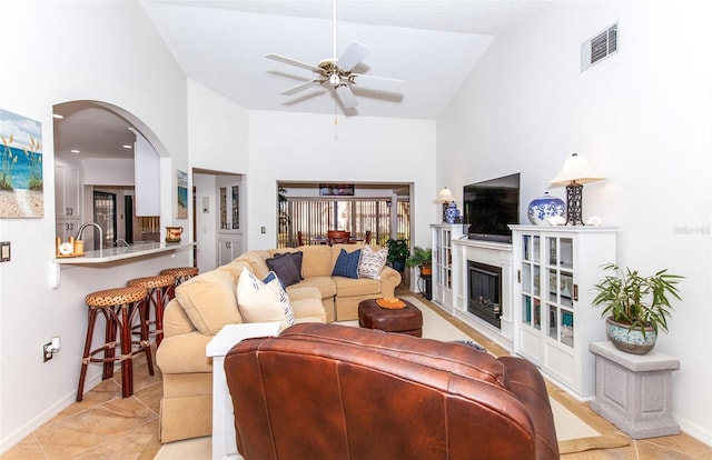 tiled living room with lofted ceiling and ceiling fan