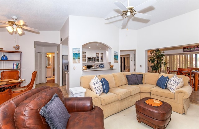 carpeted living room featuring ceiling fan, lofted ceiling, and a textured ceiling