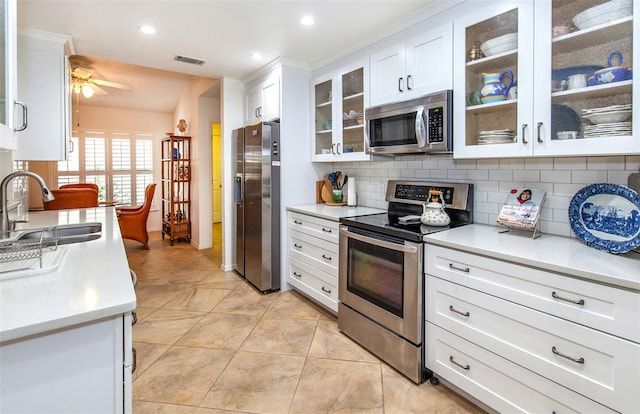 kitchen featuring sink, white cabinetry, appliances with stainless steel finishes, ceiling fan, and decorative backsplash