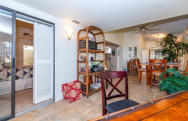 interior space with light tile patterned floors and ceiling fan