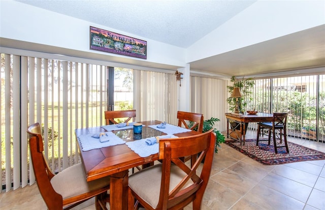 dining space with lofted ceiling and a textured ceiling