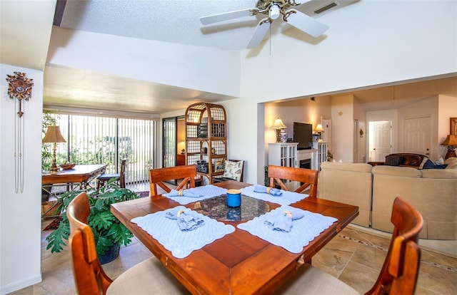 dining area featuring ceiling fan and a textured ceiling