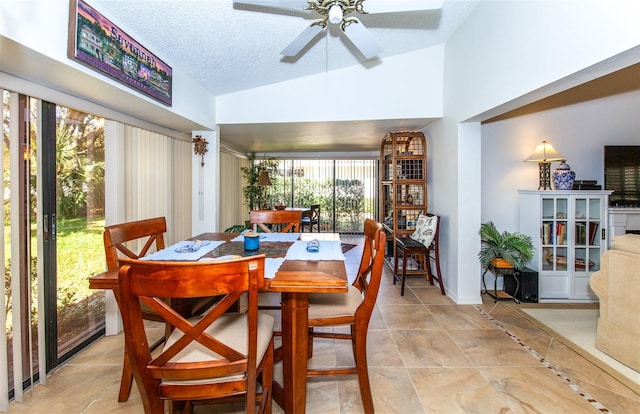 dining area with lofted ceiling, ceiling fan, and a textured ceiling