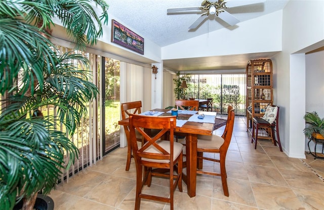 dining area with ceiling fan, vaulted ceiling, and a textured ceiling