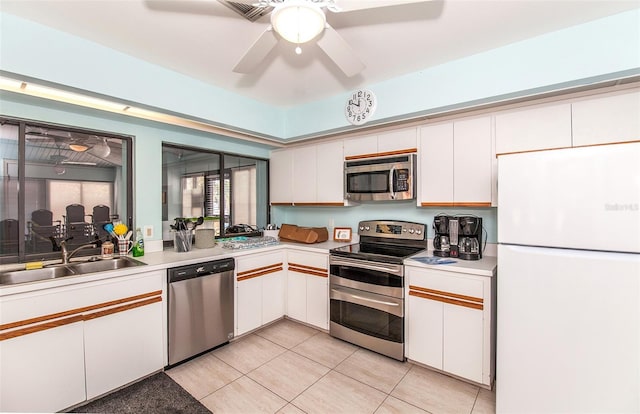 kitchen featuring sink, white cabinetry, light tile patterned floors, appliances with stainless steel finishes, and ceiling fan