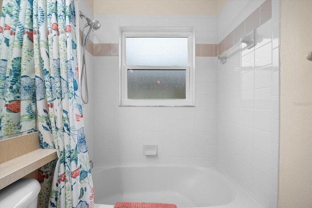 bathroom with shower / bath combination with curtain and toilet