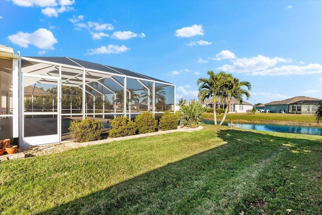 view of yard featuring glass enclosure and a water view