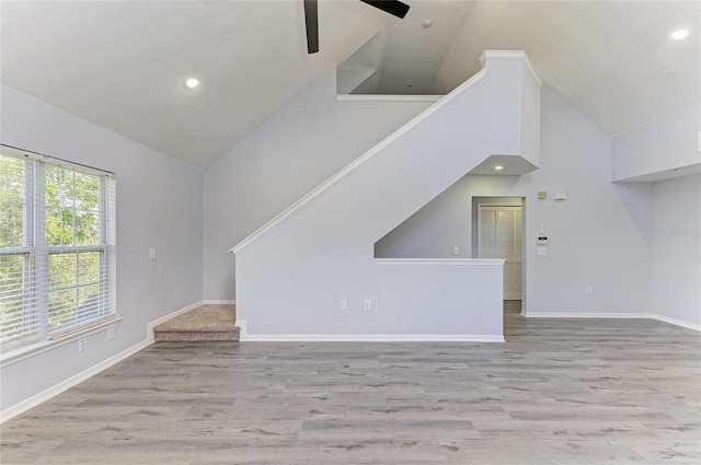 unfurnished living room with light hardwood / wood-style flooring, high vaulted ceiling, and ceiling fan