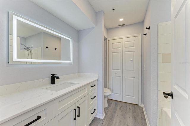 full bathroom featuring shower / tub combination, wood-type flooring, vanity, and toilet