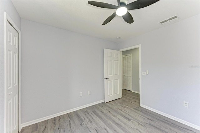 unfurnished bedroom featuring a closet, ceiling fan, and light wood-type flooring