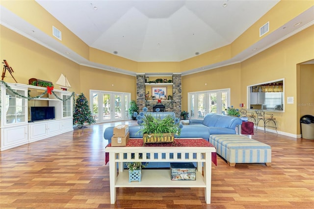 living room with hardwood / wood-style floors, a wealth of natural light, french doors, and a high ceiling