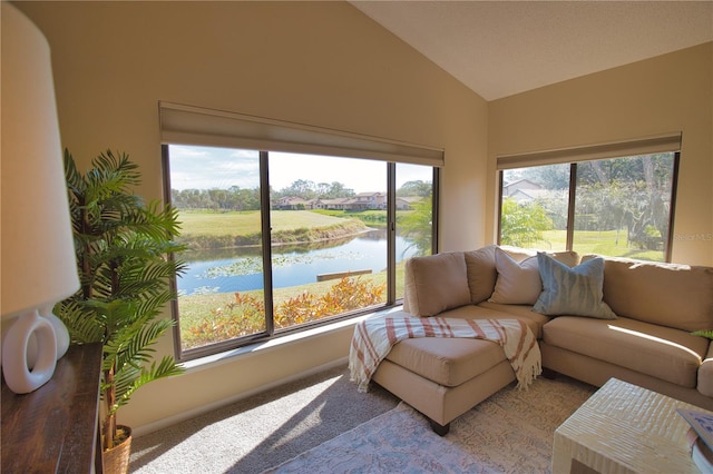 sunroom with lofted ceiling and a water view