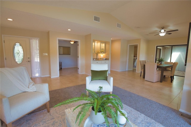 living room featuring vaulted ceiling, plenty of natural light, sink, and light tile patterned floors