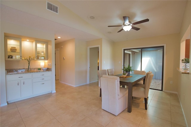 tiled dining space featuring lofted ceiling and ceiling fan