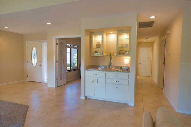 tiled entrance foyer with a textured ceiling