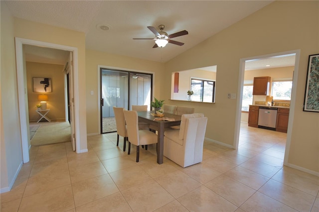 dining room with ceiling fan, vaulted ceiling, and light tile patterned floors