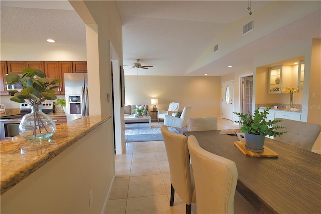 dining area with light tile patterned flooring, ceiling fan, and lofted ceiling