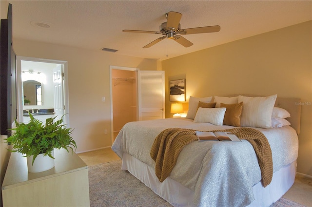 bedroom featuring ceiling fan, light colored carpet, and a textured ceiling