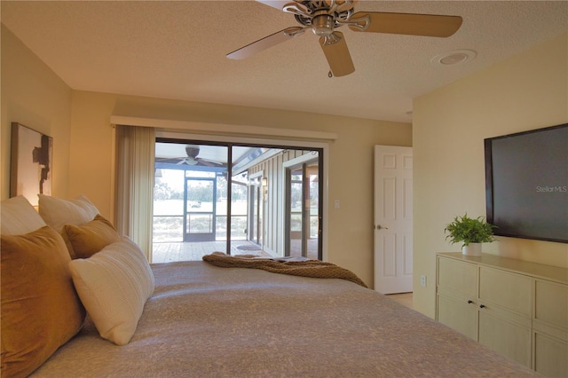 bedroom with ceiling fan, access to outside, and a textured ceiling