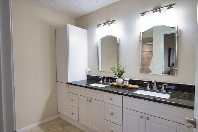 bathroom featuring tile patterned flooring, vanity, and a textured ceiling