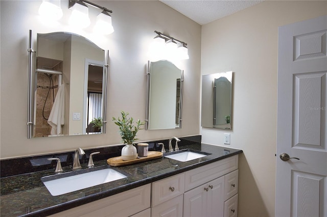 bathroom with vanity, a shower with door, and a textured ceiling