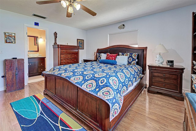 bedroom featuring ensuite bathroom, ceiling fan, and light wood-type flooring