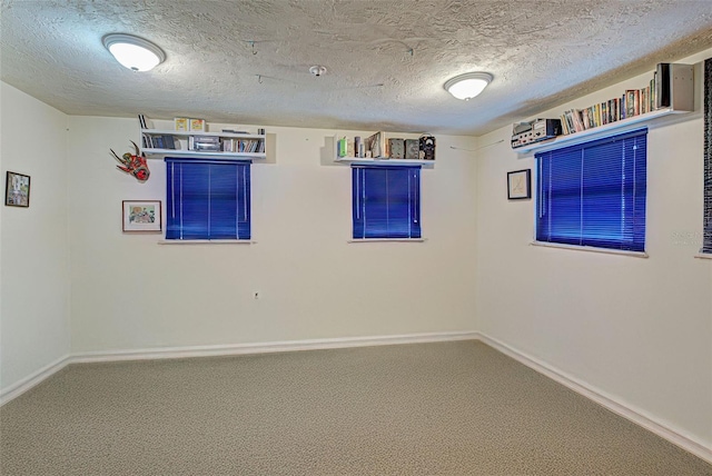 carpeted empty room with a textured ceiling