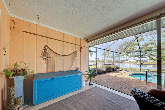 view of patio with a lanai and a water view