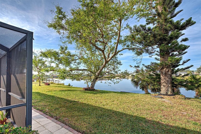 view of yard featuring a water view and glass enclosure