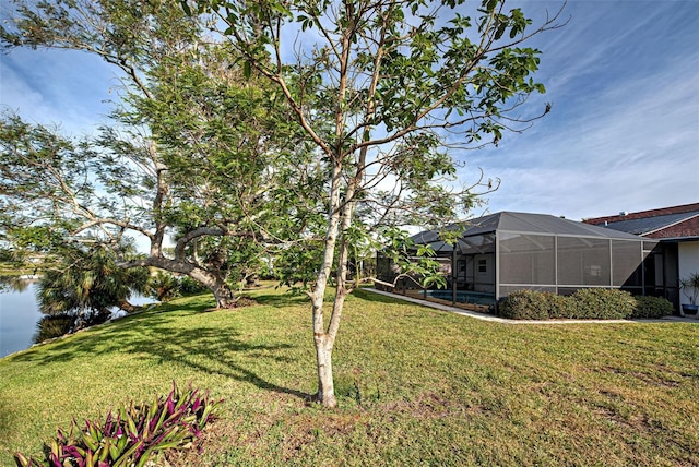 view of yard featuring a water view and glass enclosure