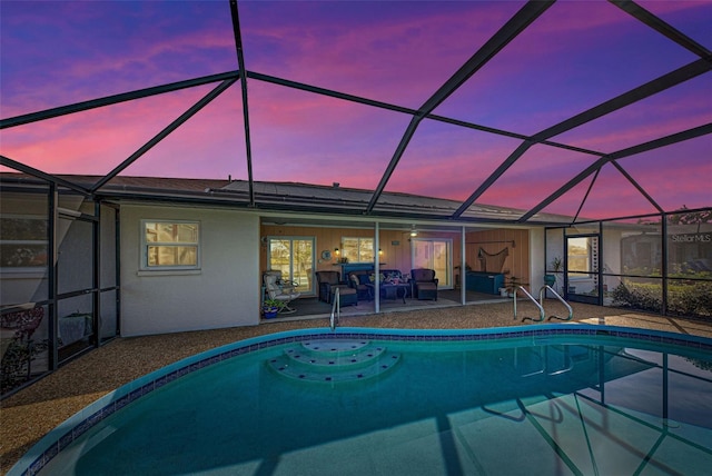 pool at dusk featuring a patio and glass enclosure