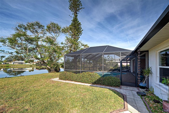 view of yard with a lanai and a water view