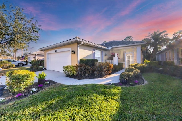 single story home with a garage and a yard