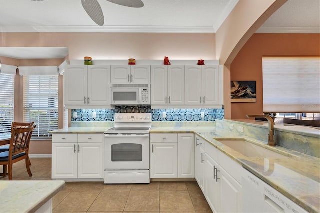 kitchen featuring light tile patterned flooring, white cabinetry, sink, crown molding, and white appliances