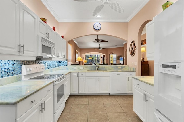 kitchen featuring white cabinetry, white appliances, kitchen peninsula, and sink