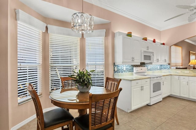 kitchen featuring white appliances, crown molding, white cabinetry, decorative backsplash, and decorative light fixtures