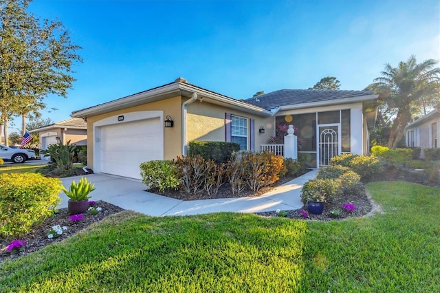 ranch-style house with a garage, a sunroom, and a front yard