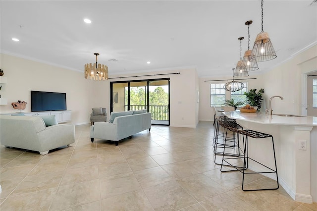 living room featuring sink, crown molding, a notable chandelier, and light tile patterned flooring