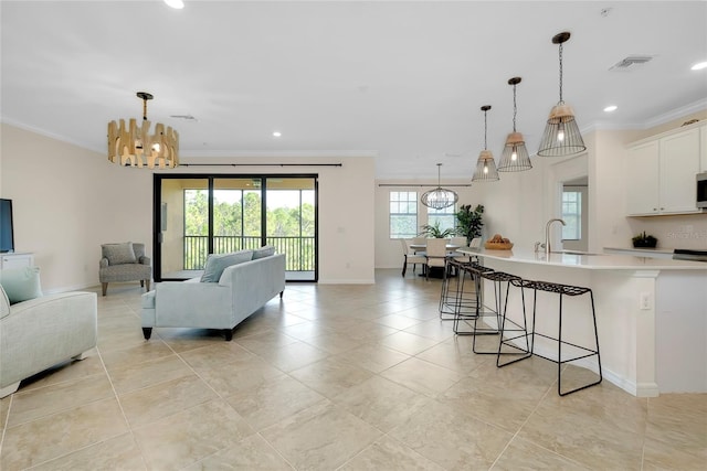 tiled living room with an inviting chandelier, crown molding, and sink