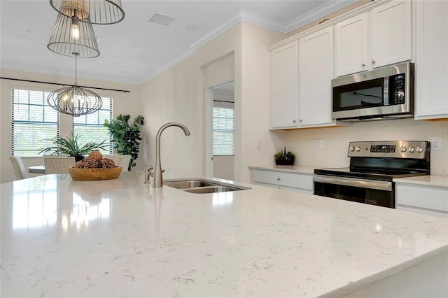 kitchen with sink, appliances with stainless steel finishes, hanging light fixtures, light stone counters, and white cabinets