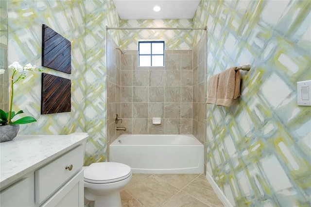 full bathroom featuring tile patterned floors, toilet, tiled shower / bath, tile walls, and vanity