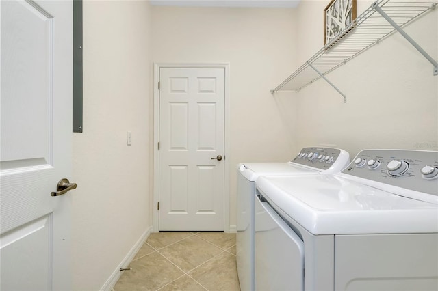 laundry area with light tile patterned floors and washing machine and clothes dryer