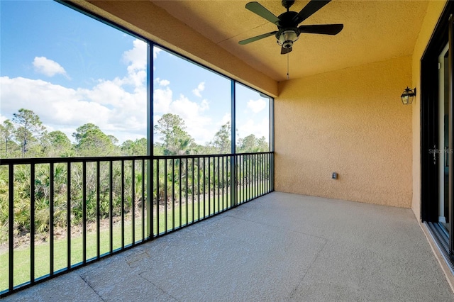 unfurnished sunroom with ceiling fan