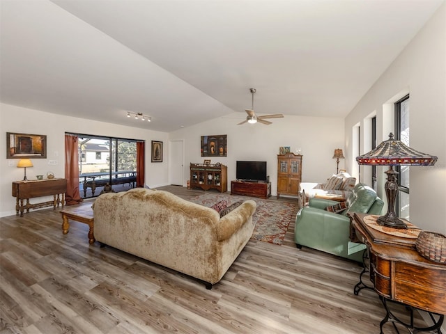 living room featuring hardwood / wood-style flooring, ceiling fan, and vaulted ceiling