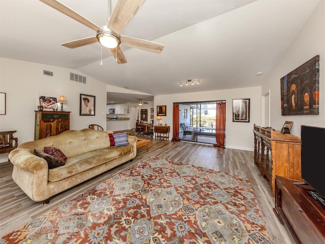 living room featuring lofted ceiling, hardwood / wood-style flooring, and ceiling fan