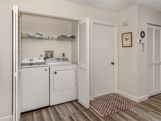 laundry room with separate washer and dryer and light wood-type flooring