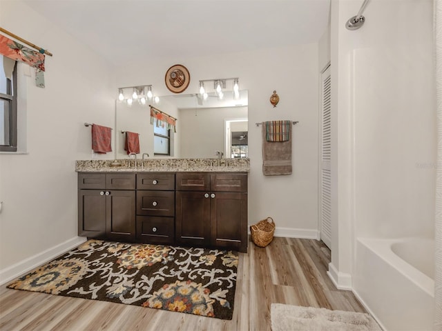 bathroom featuring hardwood / wood-style flooring, vanity, and a bathtub