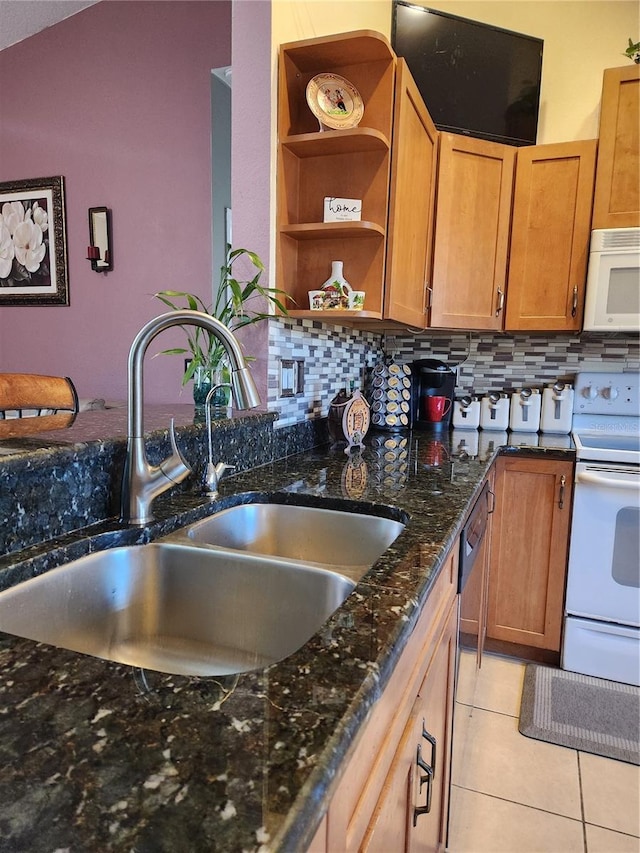 kitchen featuring sink, white appliances, light tile patterned floors, decorative backsplash, and dark stone counters