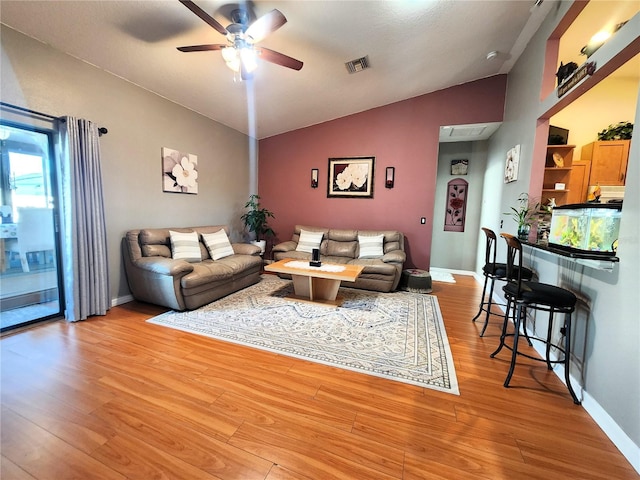 living room featuring ceiling fan, light hardwood / wood-style floors, and vaulted ceiling